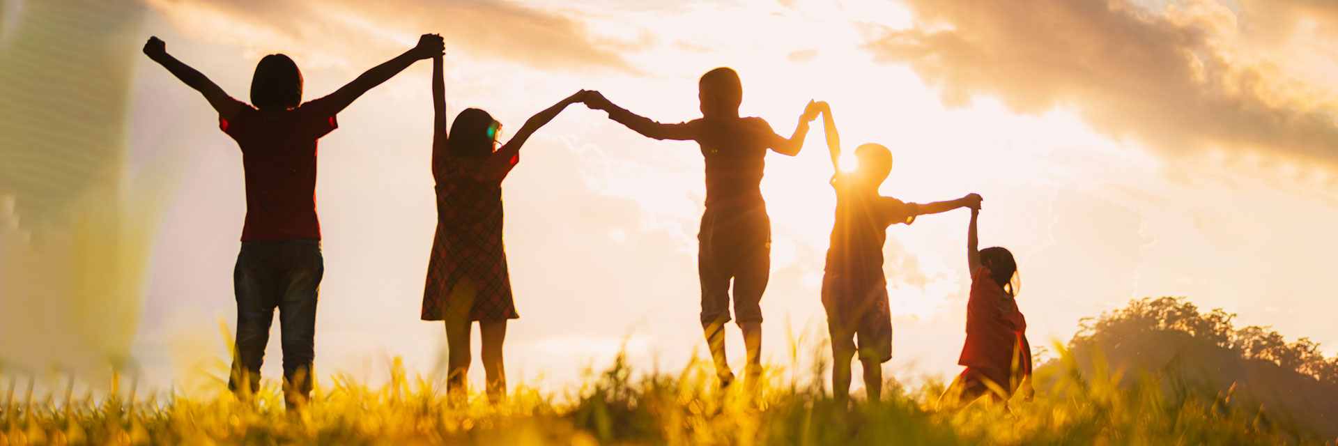 Familie die sich an den Händen hält und dem Himmel entgegen strecken  